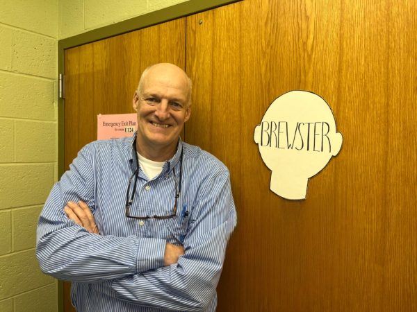 Mr. Phil Brewster standing in his classroom ready to welcome students with a smile.