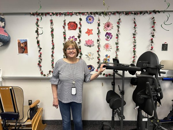 Mrs. Bones poses in her classroom, surrounded by the equipment used by her students.