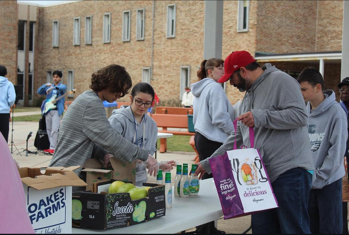 Members of Sharing Excess hand out goods at their Free Food Fest in January