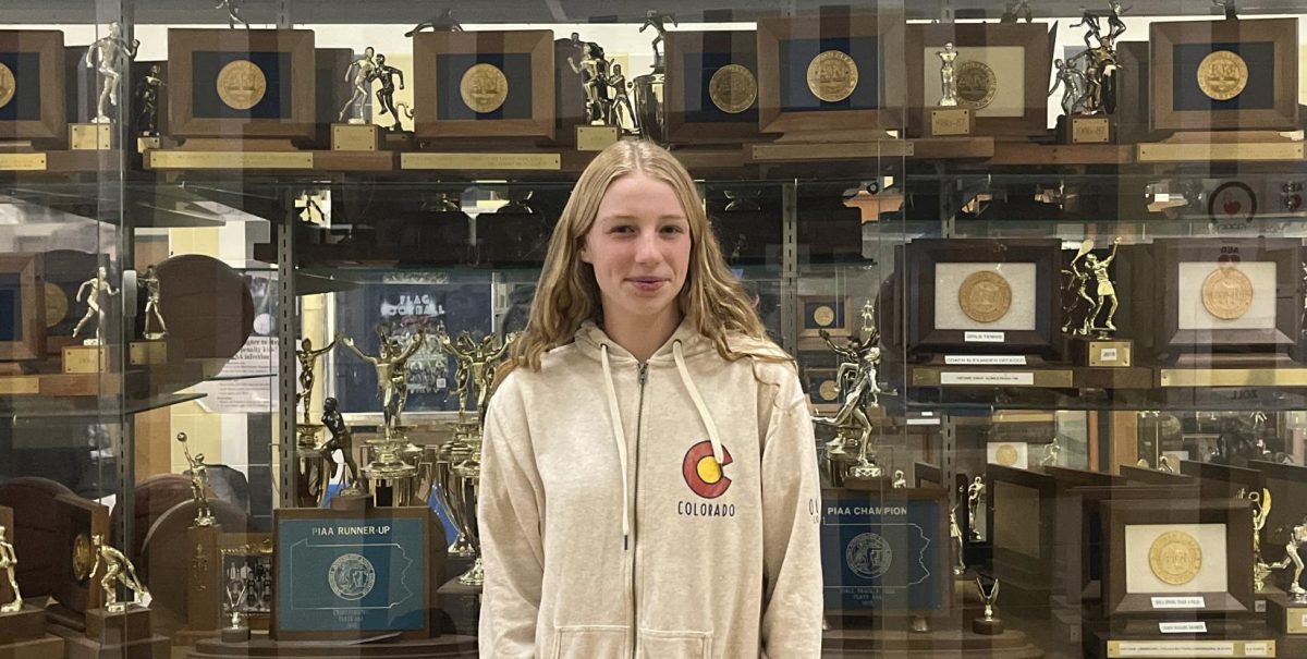 North Penn sophomore, Bailey Wagner, in front of track and field trophies like the ones she hopes to earn later in her career