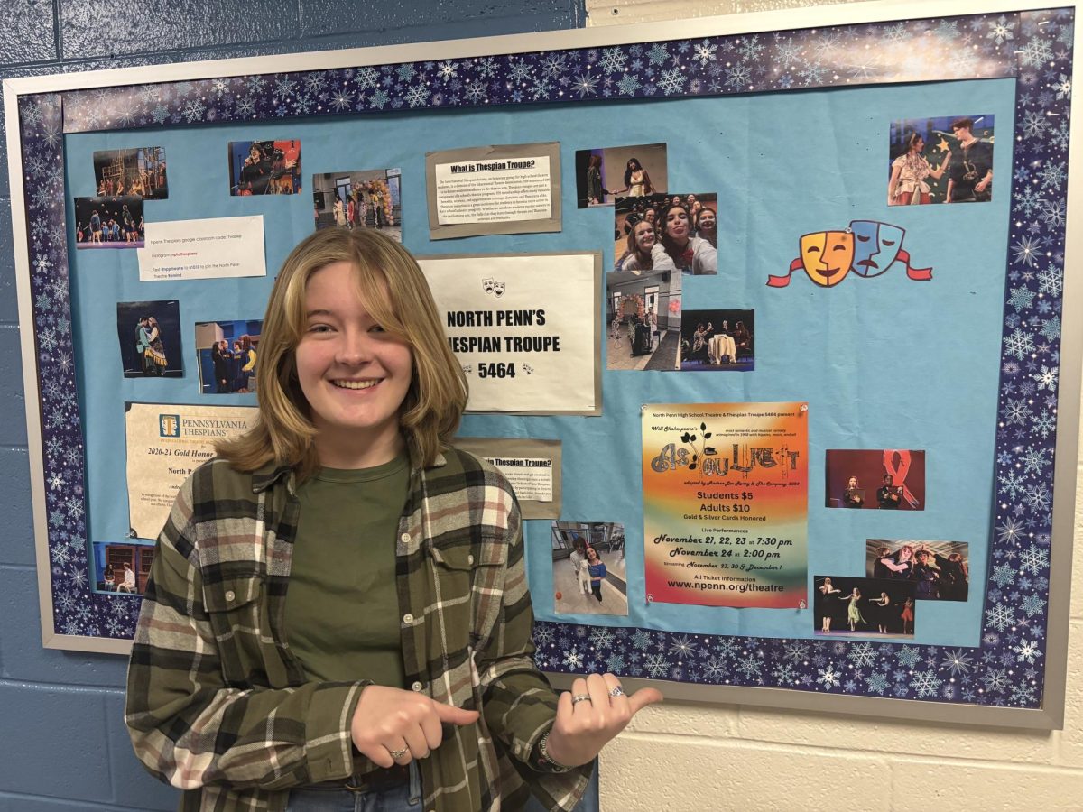 North Penn senior, Cece Ahart, stands in front of the thespian troupe's bulletin board in the theater hallway. 