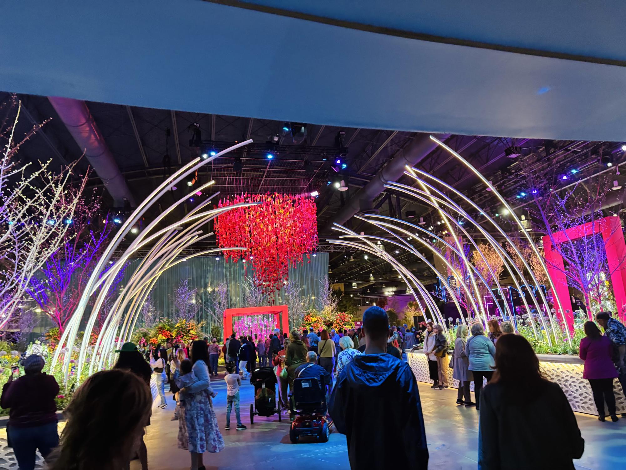 The archway leads guests in the entrance way, followed by a large overhead floral piece done in red. 